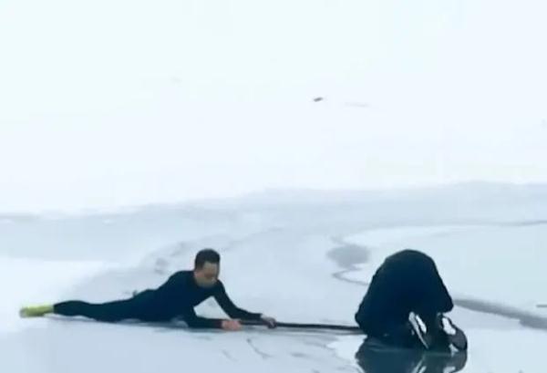 赌上生命的救援！两男子传递竹竿徒手凿冰救出落水男孩